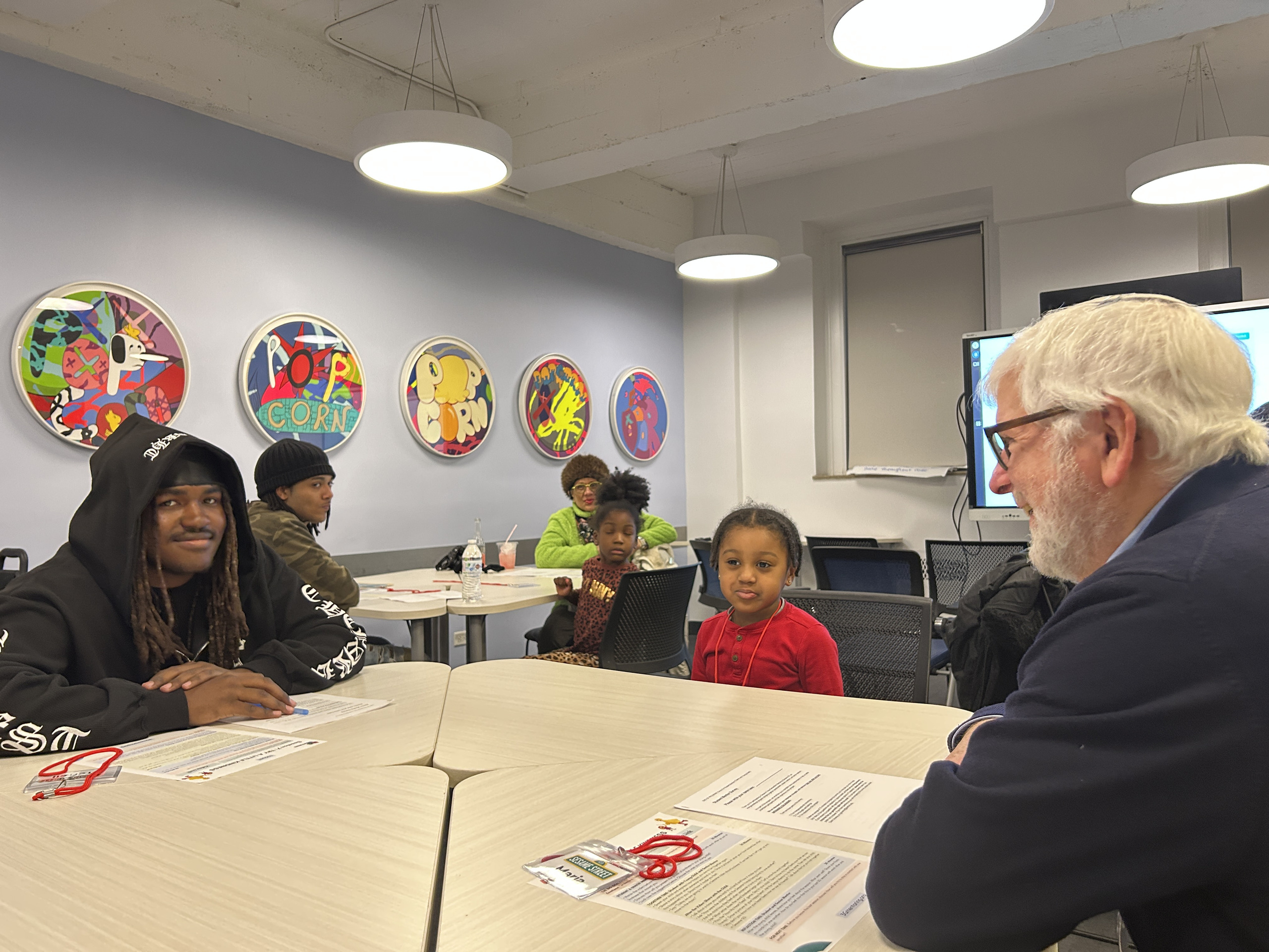 Older adult, teen mentor and child at a session table